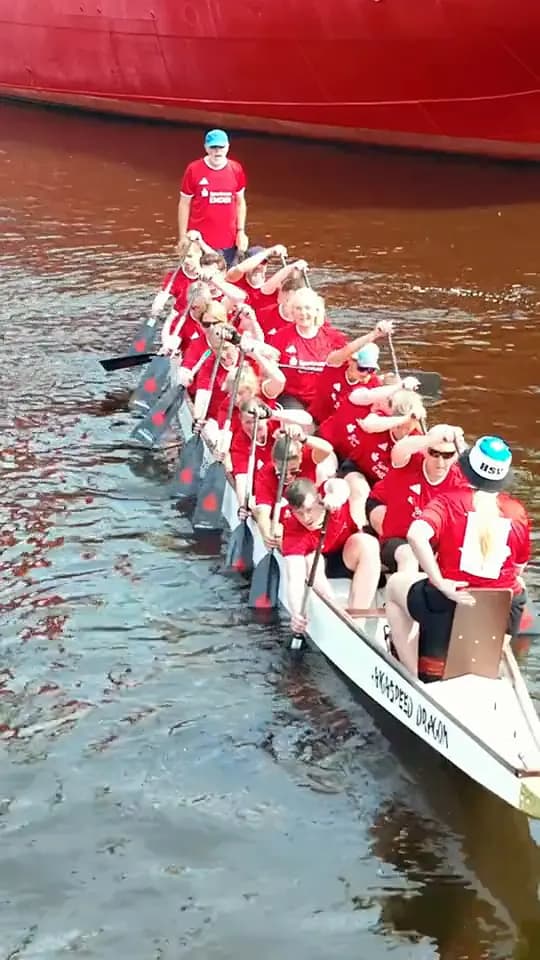 Rotes Team im Drachenboot, nah aus der Luft